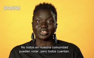 Black woman wearing interesting earrings looking into the camera